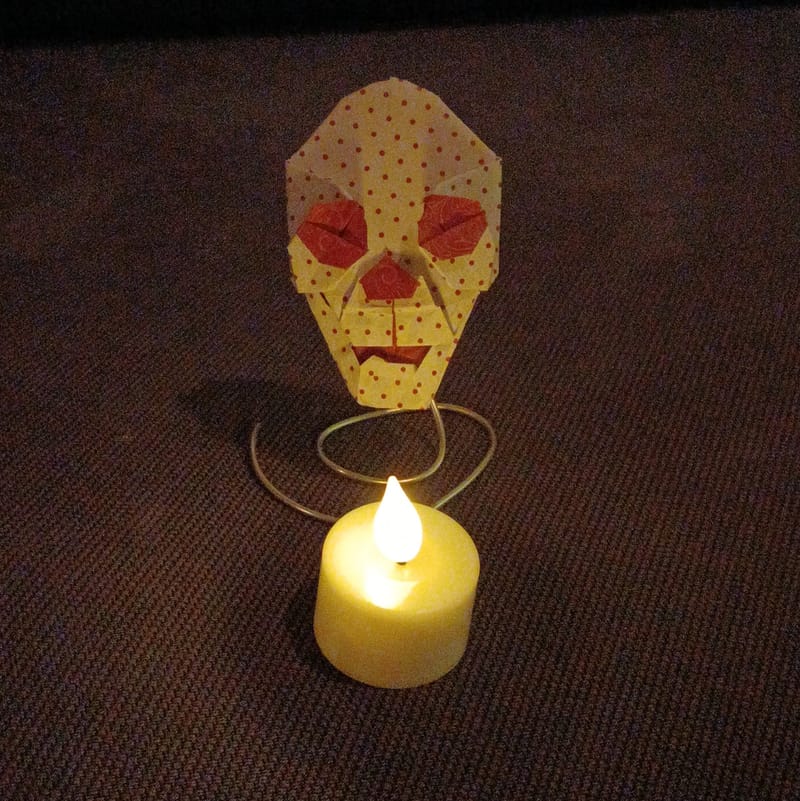 Skull origami with candle in front